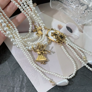 Multi-layer pearl necklace with vintage gold angel pendant and tassel detail