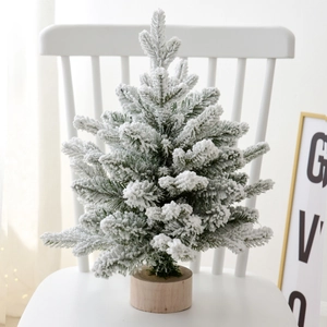 Mini tabletop snowy Christmas tree with white flocking and round wooden base for decor