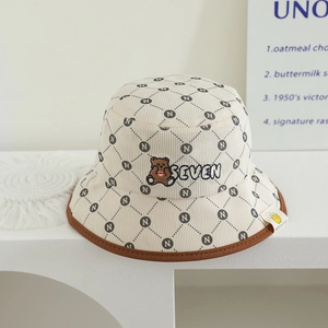 Détail d'un chapeau bob pour enfant en velours côtelé avec broderie ours et motifs N