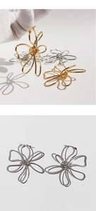Artistic gold and silver abstract hollow flower earrings shown in hand and on flat lay