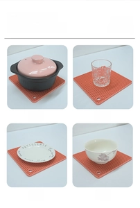 Detail of square honeycomb silicone placemat for pots and bowls in orange finish