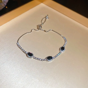 Detailed close-up of adjustable silver bracelet with three black oval zircon stones