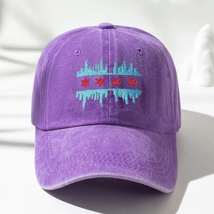 Detailed embroidery of red stars and blue skyline on a washed purple cotton baseball cap