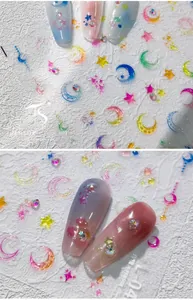 Detailed macro view of 5D embossed rainbow moon and star nail art stickers with rhinestones