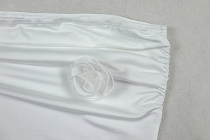 Detailansicht der weißen Mesh-Blumenverzierung und Raffung am asymmetrischen Kleid