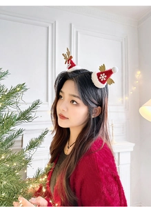 Détail de serre-tête de Noël avec mini bonnet rouge, bois dorés et ailes en peluche douce