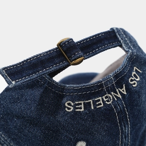 Detail of denim baseball cap with Los Angeles embroidery and brass adjustable metal buckle
