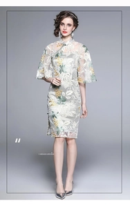 Detail of floral embroidery on light green cheongsam dress with sheer mesh bell sleeves