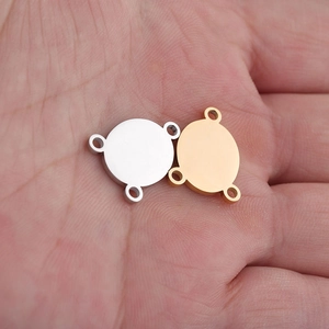 Macro detail of gold and silver jewelry connectors with three loops held in hand