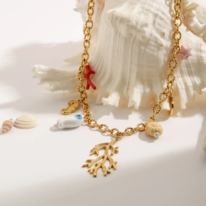 Golden stainless steel ocean necklace with coral and shell charms on a large seashell