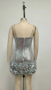 Detail of silver sequin dress hem featuring large 3D rose and ruffled fabric edge