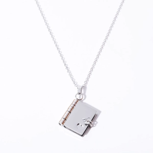 Silver stainless steel book locket necklace with hollow heart detail on white background