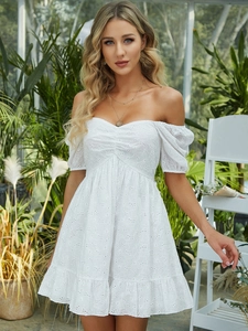 Close-up of white off-the-shoulder lace dress with intricate hollow embroidery and puff sleeves