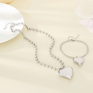 Detailed set of silver stainless steel heart pendant necklace and beaded bracelet