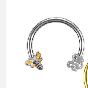 Detail of surgical steel horseshoe ring with honeybee design and zircon honeycomb studs
