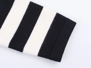 Close-up of black and white striped knit fabric showing detailed texture and cuffs