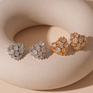 Exquisite gold and silver heart-shaped stud earrings with zircon in creative display