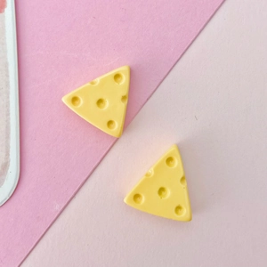 Macro shot of two miniature yellow resin cheese charms with realistic hole details