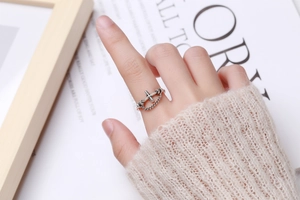 Close-up of S925 sterling silver vintage cross ring with chain detail on a finger