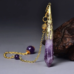 Close-up of natural amethyst hexagonal prism pendant with ornate gold lace metal cap