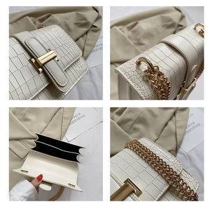 Detail view of white crocodile pattern bag with gold chain and dual compartments