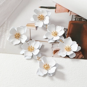 Elegant triple white flower drop earrings with golden pistils in minimalist design