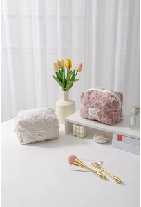 Close-up of 3D lace flower embroidery and textured corduroy on cosmetic storage bag