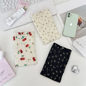 Pochettes de téléphone en mousseline fleurie avec bouton sur un décor de bureau