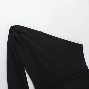 Détail de l'encolure asymétrique d'une combinaison noire en tissu sergé extensible