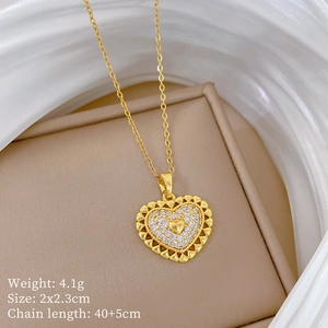 Detailed close-up of a gold hollow heart pendant with sparkling crystals on a beige base