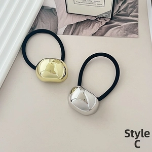 Close-up of gold and silver metallic bean hair ties with mirror polished finish detail