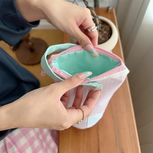Detail showing pink checkered canvas pencil case with mint green handle and spacious interior