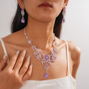 Detail of vintage style necklace and earrings set with purple zircon floral pattern