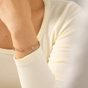 Elegant gold and silver stainless steel bracelet with zircon inlay on female wrist