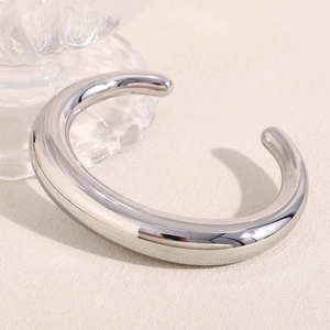 Macro view of wide minimalist silver-plated cuff bracelet with high polished finish