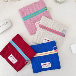 Detail view of colorful nylon storage pouches with contrast zippers and woven label