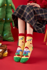Close-up of yellow Christmas coral fleece socks with cute dwarf embroidery and red cuffs