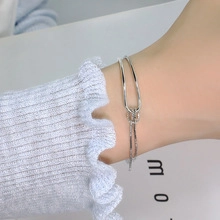 Minimalist double-layered silver bracelet featuring interlocking curved metal lines for women