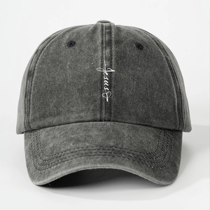 Close-up of Jesus embroidery and heart cross on washed grey cotton baseball cap
