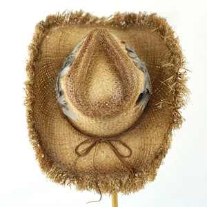 Detailed top view of a Raffia cowboy straw hat with feather trim and frayed edges