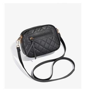 Detail of black quilted leather camera bag featuring premium gold hardware and zippers