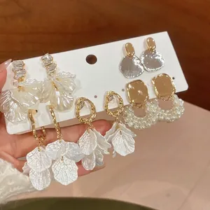 Élégant ensemble de quatre paires de boucles d'oreilles perles et pétales dorés