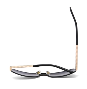 Detailed view of sunglasses with golden temples featuring an intricate checkered pattern