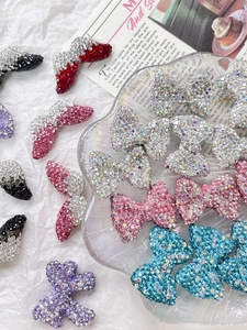 Close-up of sparkling rhinestone bow charms in various colors for DIY jewelry making