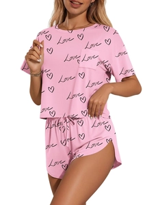 Detail of pink lounge set showing 'Love' print and heart patterns on the fabric