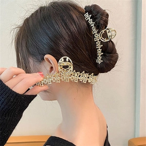 Detail of a gold alloy hair clip with cutout Chinese characters on a woman hairstyle