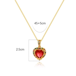 Macro shot of 18K gold heart pendant with red zircon and colorful stones detail