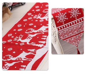 Macro detail of red knitted Christmas runner with white reindeer patterns and decorative tassels
