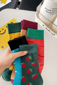 Detailed close-up of colorful cotton socks with vibrant strawberry and carrot patterns