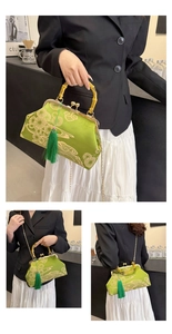 Detail der grünen Satin-Handtasche mit Bambusgriff, Blumenstickerei und Goldkette